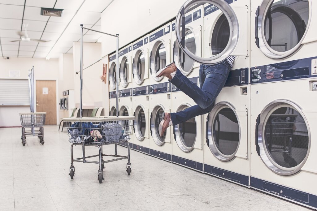 family laundry day with big comforter at laundromat