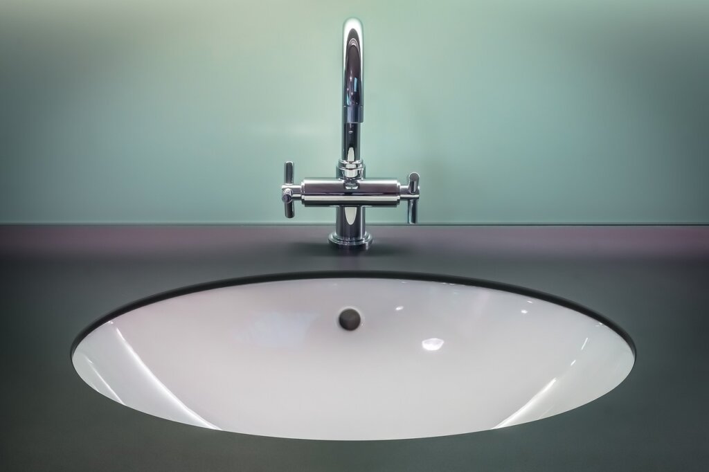 stainless steel grill pan soaking in sink overnight with soap bubbles