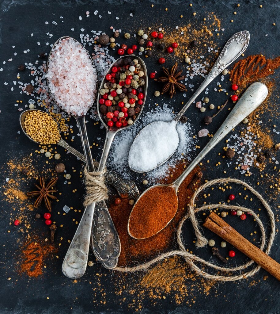 citric acid powder being measured into a small spoon on kitchen counter