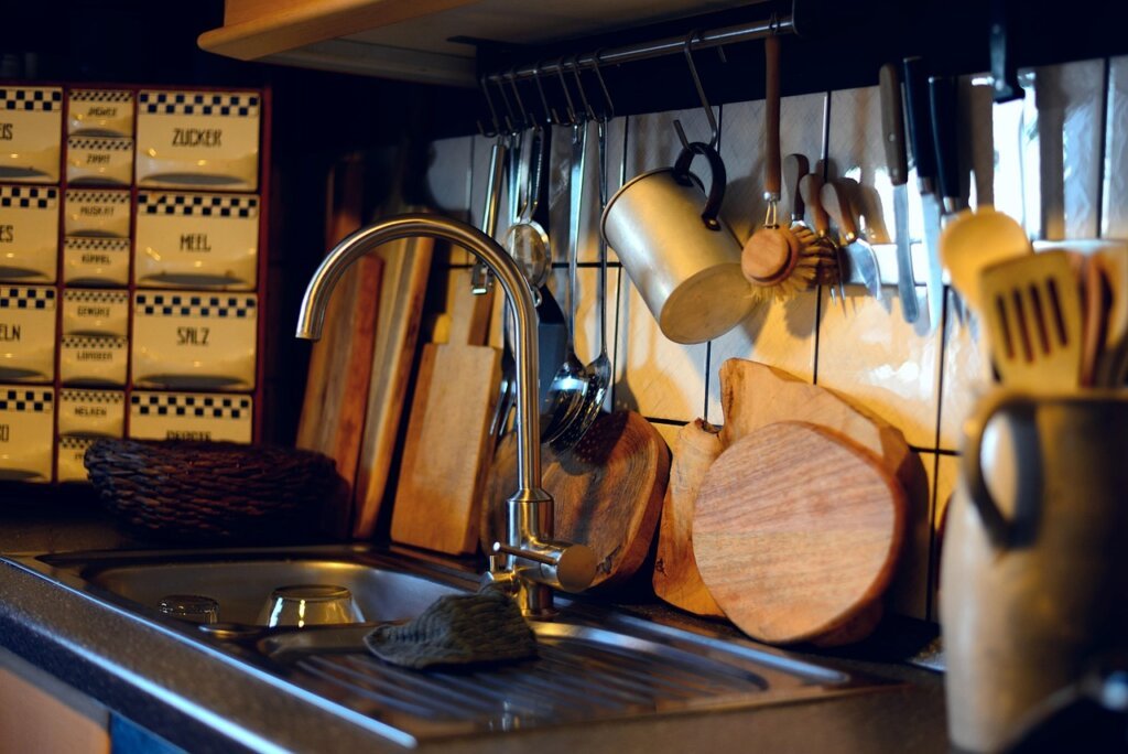 wet wooden cutting board lying flat on kitchen sink
