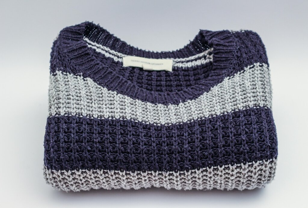neatly folded wool knit sweaters stored flat in a drawer