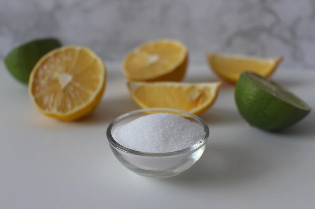 baking soda and citric acid in small bowls next to white fabric