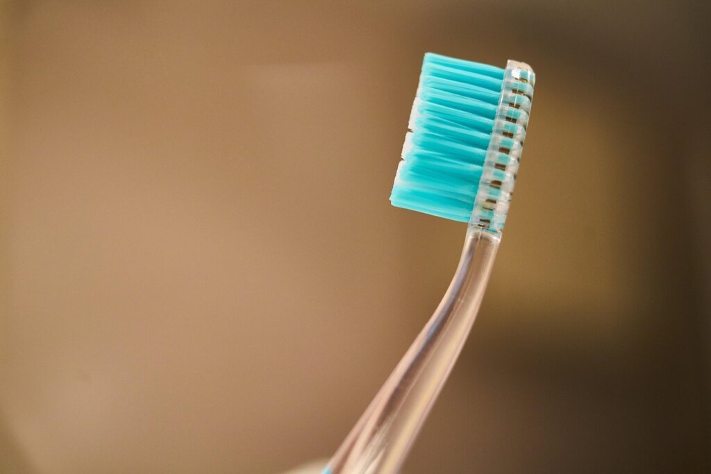 cleaning mold with ethanol solution using old toothbrush on cabinet wood