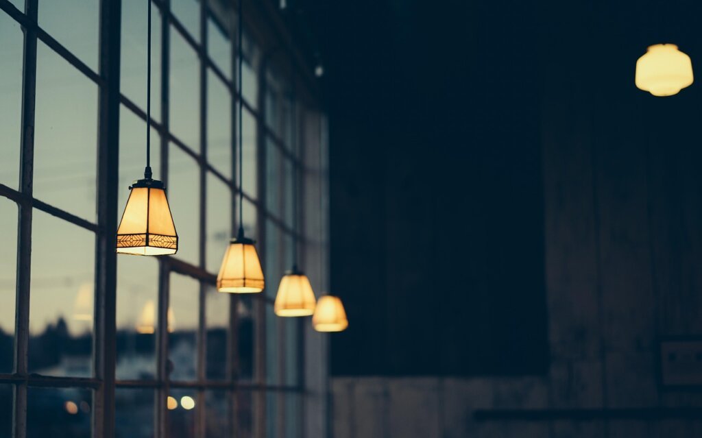 thick thermal blackout curtain hanging over apartment window at night with warm interior light