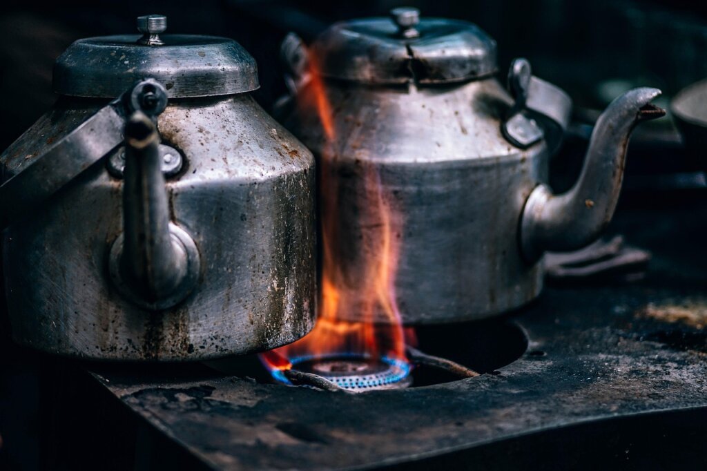 white towels boiling in large stainless pot with steam