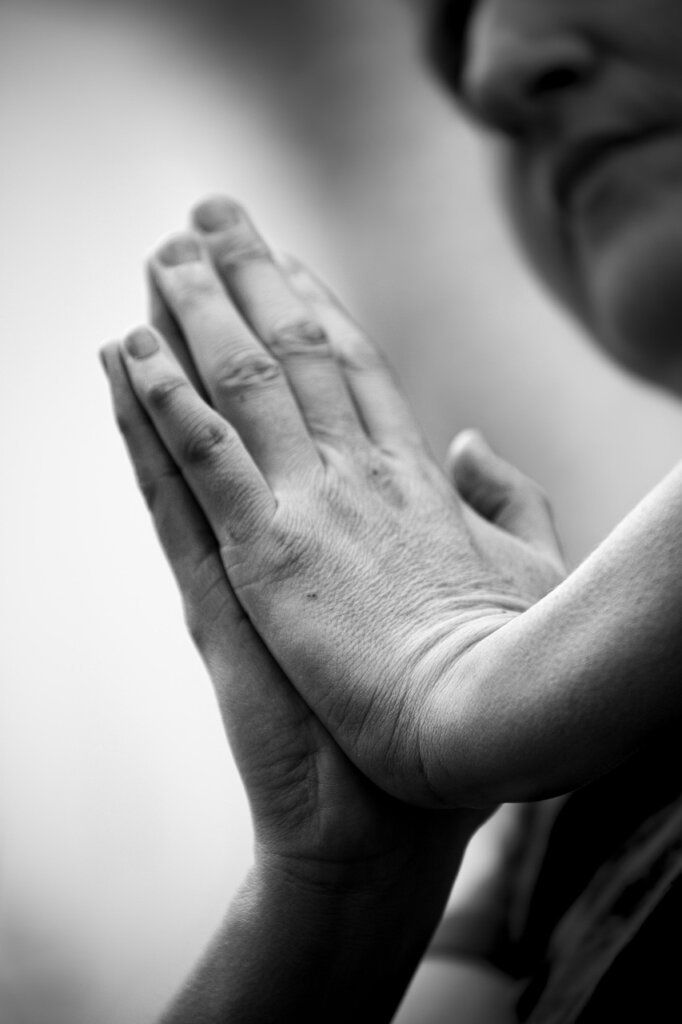 spray bottle being shaken before use, close-up hands