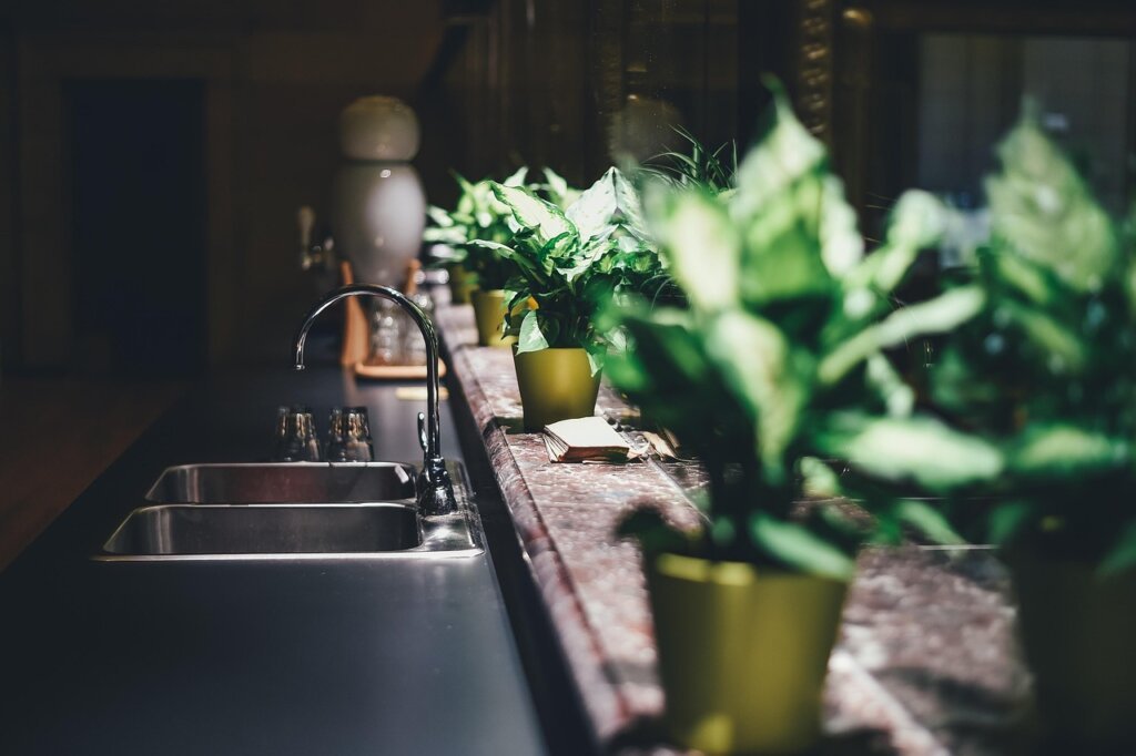 baking soda and vinegar being poured into kitchen sink drain