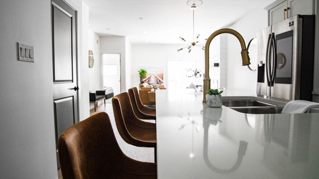 person wiping kitchen sink area with cloth in tidy apartment