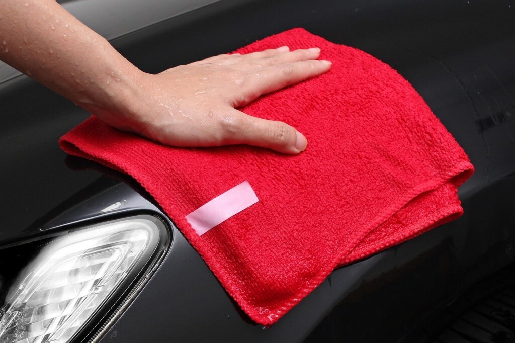 microfiber cloth and eyeglass cleaning spray on white background
