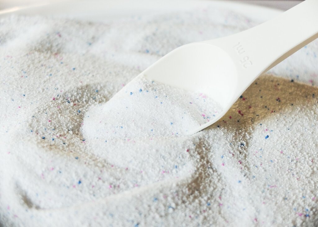 liquid detergent being poured into washing machine drawer