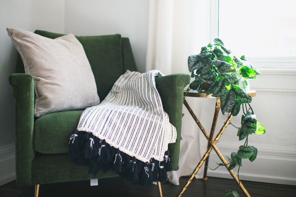 person folding clean summer blanket at home with sunlight