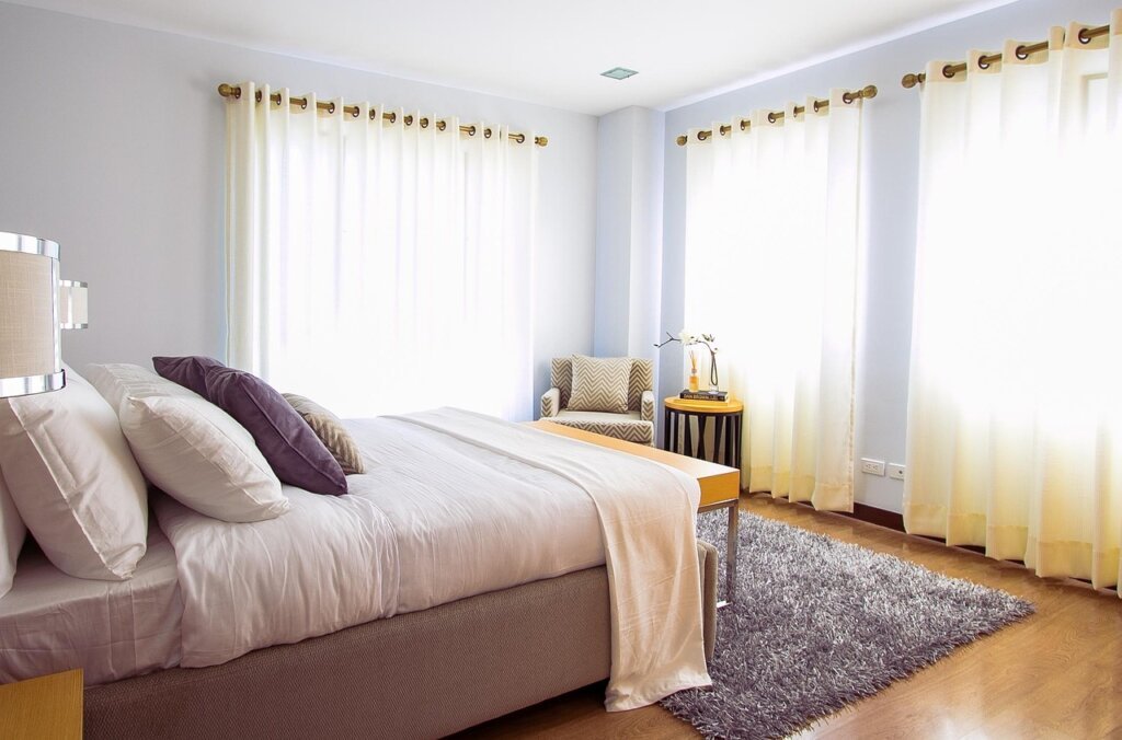 small bedroom furniture pushed against wall with open floor space